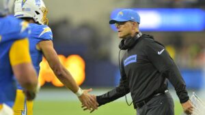 LA Chargers head coach Jim Harbaugh high-fives quarterback Justin Herbert after a touchdown against the Denver Broncos