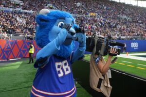 Buffalo Bills mascot Billy Buffalo interacts with WHAM TV camera person Jenna Cottrell during an NFL International Series game