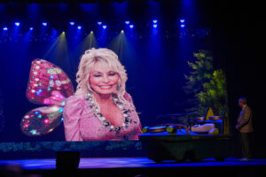 Dolly Parton speaks during a prerecorded video in the Celebrity Theater for the first day the NighFlight Expedition ride opens