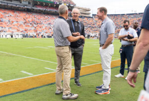 SEC Commissioner Greg Sankey, middle, talks with Auburn Athletic Director John Cohen, right, during warm ups before Auburn