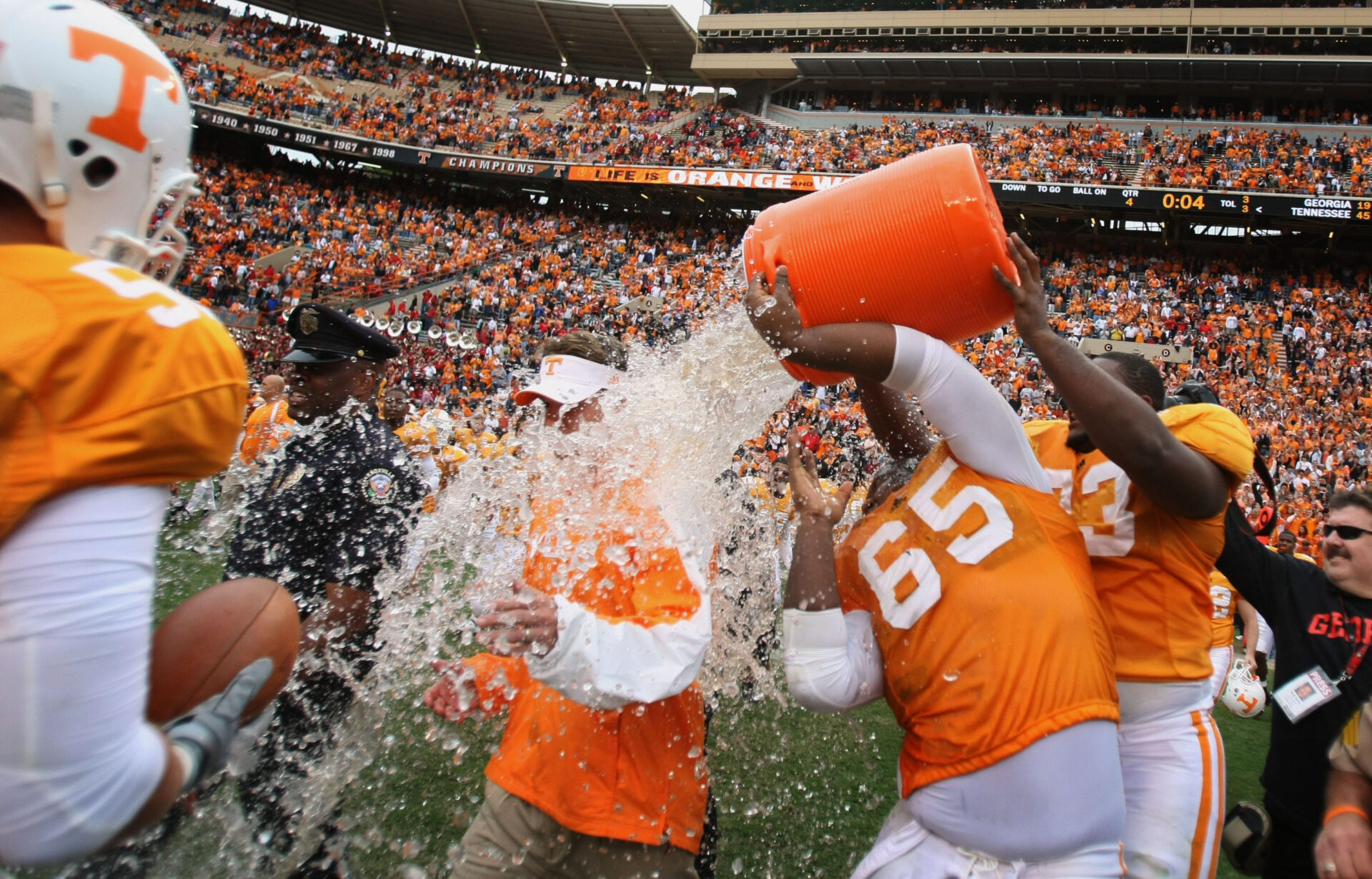 Tennessee guard Jacques McClendon (65) pours water on Head Coach Lane Kiffin after his first SEC win after the University of