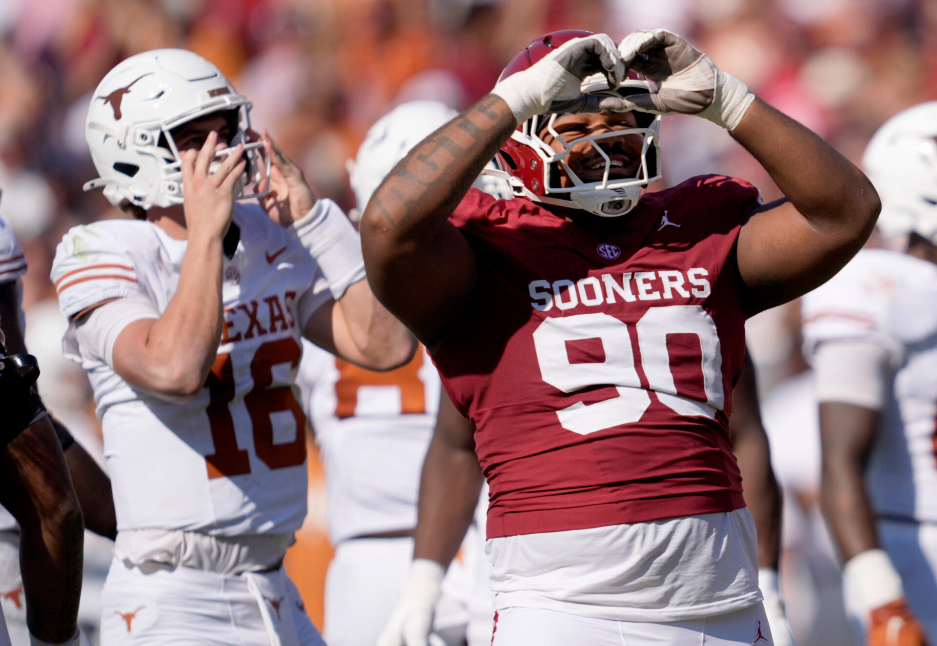 Oklahoma's Trent Wilson (90) celebrates a defensive play next to Texas' Arch Manning (16) in the first half of the Red River
