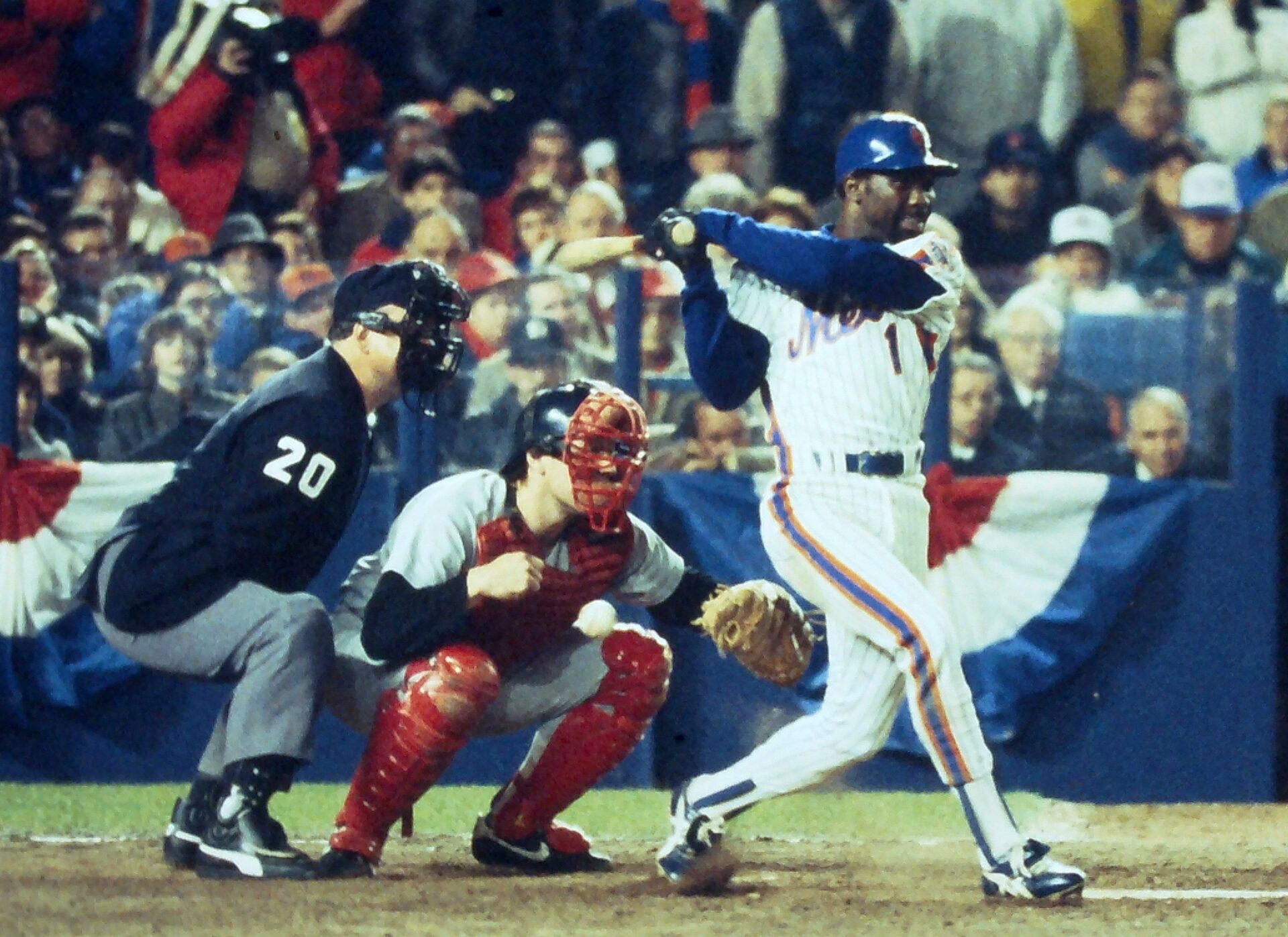 Mets' Mookie Wilson hits a slow grounder up the first base line that gets by Red Sox first basemen Bill Buckner scoring Ray